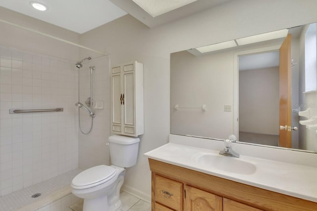 bathroom featuring vanity, tile patterned floors, toilet, and a tile shower