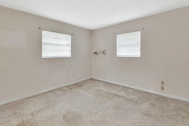 carpeted spare room featuring a textured ceiling