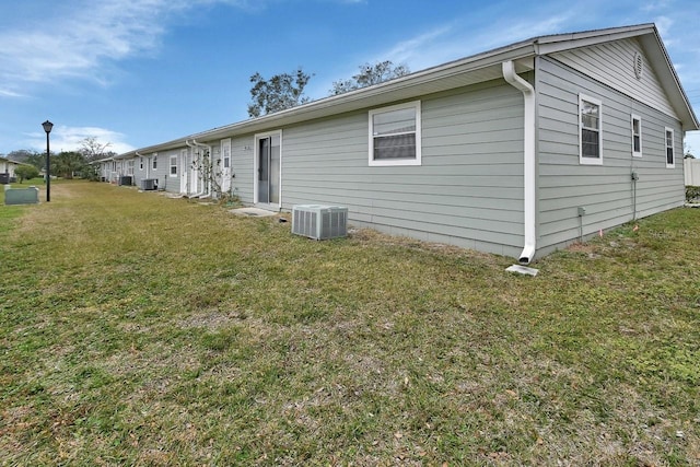 view of side of property featuring a yard and central air condition unit