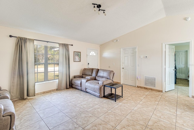 tiled living room with vaulted ceiling and a textured ceiling