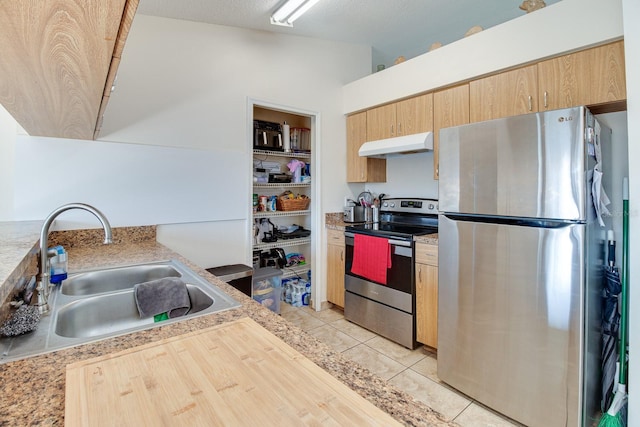 kitchen featuring appliances with stainless steel finishes, sink, light tile patterned floors, and light brown cabinetry