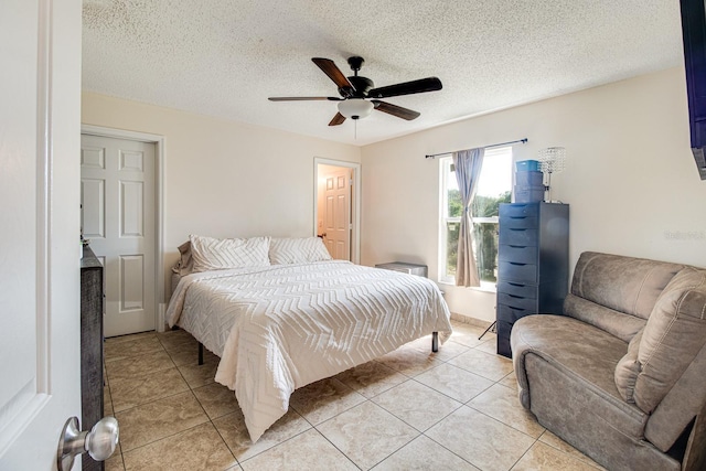 bedroom with light tile patterned flooring, ceiling fan, and a textured ceiling