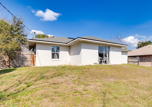 rear view of property featuring a lawn