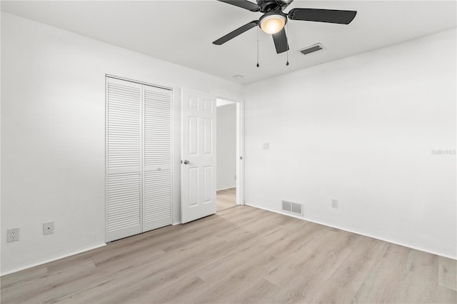 unfurnished bedroom with light hardwood / wood-style flooring, a closet, and ceiling fan