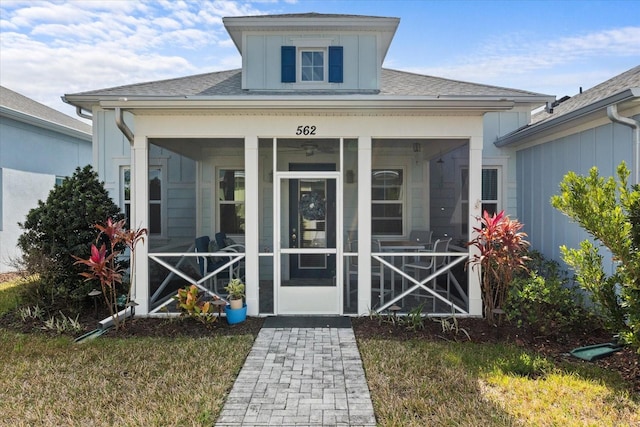 doorway to property with roof with shingles