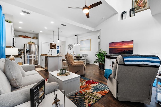 living room featuring a ceiling fan, visible vents, baseboards, recessed lighting, and dark wood-style flooring