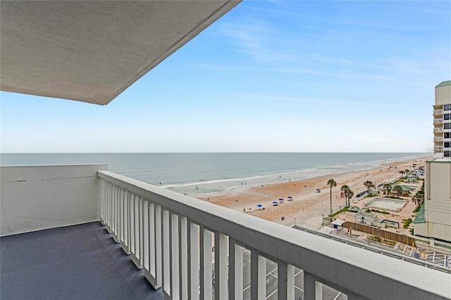 balcony featuring a view of the beach and a water view