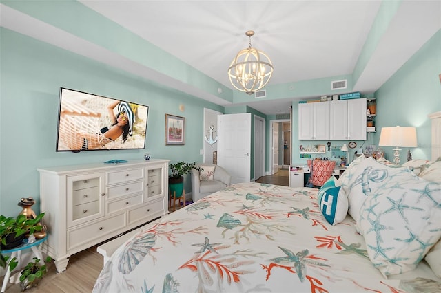 bedroom with a notable chandelier and light wood-type flooring