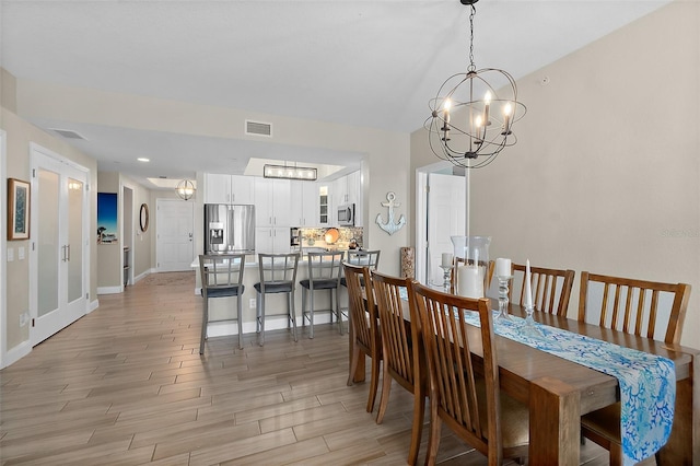 dining room with an inviting chandelier and light hardwood / wood-style floors