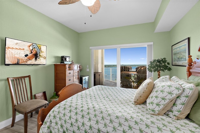 bedroom with ceiling fan, a water view, and light hardwood / wood-style floors