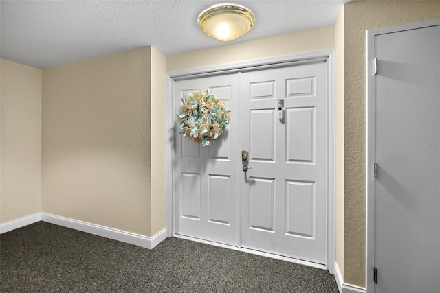 carpeted entryway with a textured ceiling