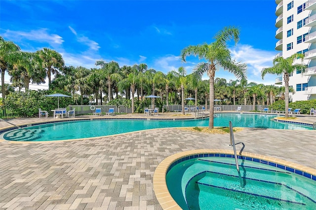 view of swimming pool with a hot tub and a patio