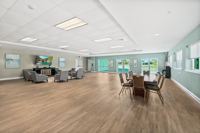 dining area with a paneled ceiling and wood-type flooring