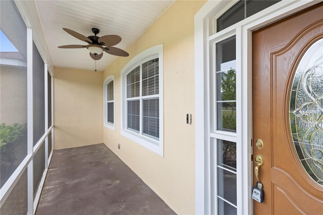 unfurnished sunroom featuring ceiling fan