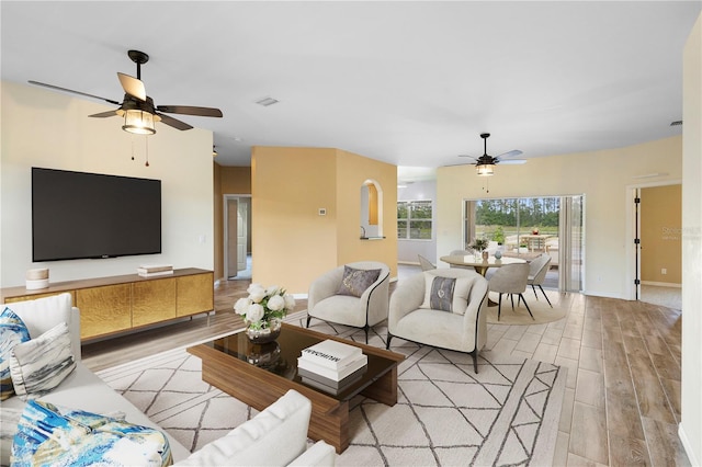 living room with ceiling fan and light hardwood / wood-style flooring