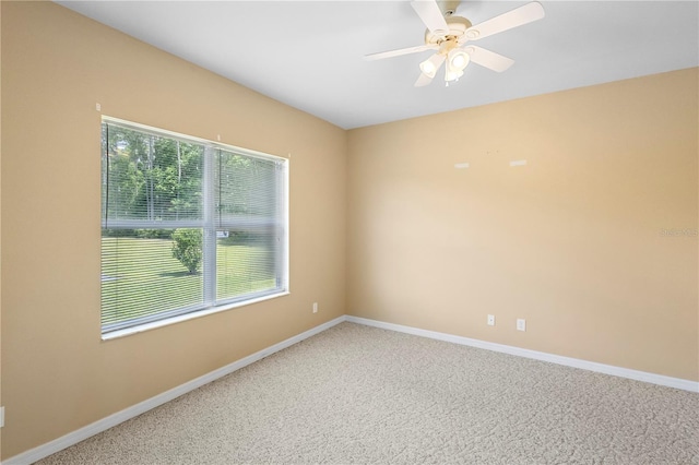 carpeted spare room with ceiling fan and plenty of natural light