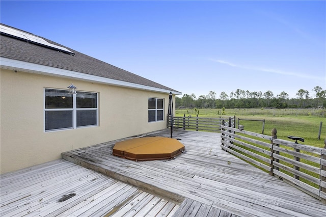 deck with a rural view and a covered hot tub