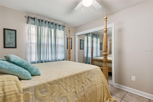 tiled bedroom featuring ceiling fan, a textured ceiling, and a closet