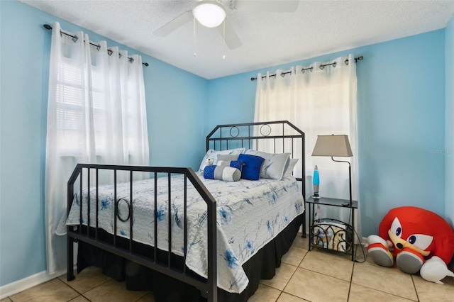 tiled bedroom featuring ceiling fan and a textured ceiling