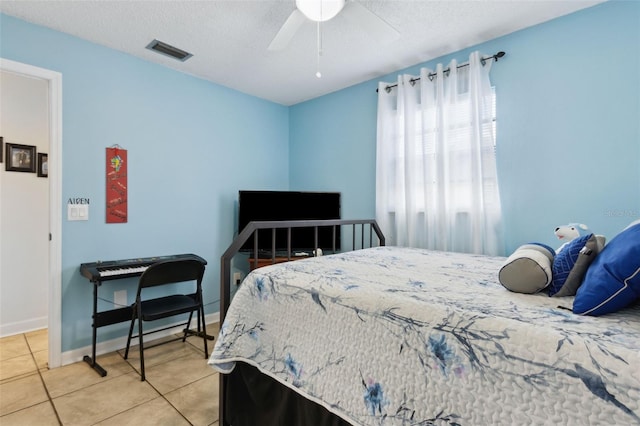 tiled bedroom with ceiling fan and a textured ceiling