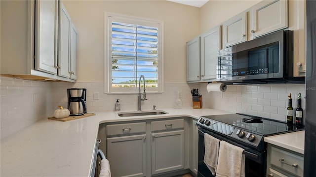 221 Aston Grande Dr, Daytona Beach, FL 32124 - kitchen with gray cabinets, sink, backsplash, and electric stove