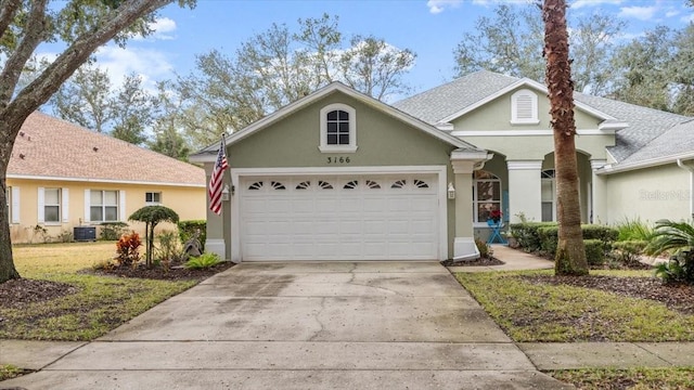 front of property featuring a garage, a front lawn, and central air condition unit