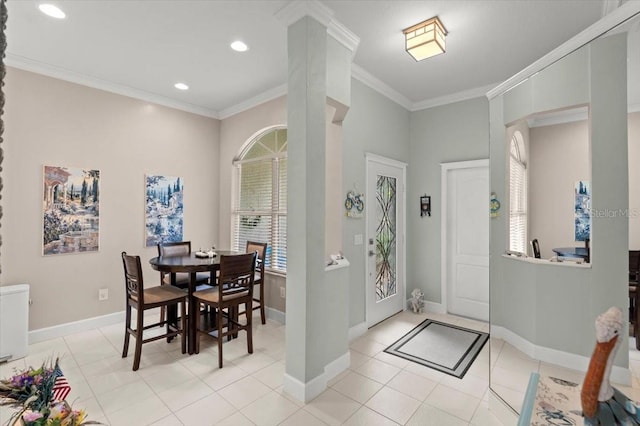 entryway featuring light tile patterned floors, crown molding, and decorative columns