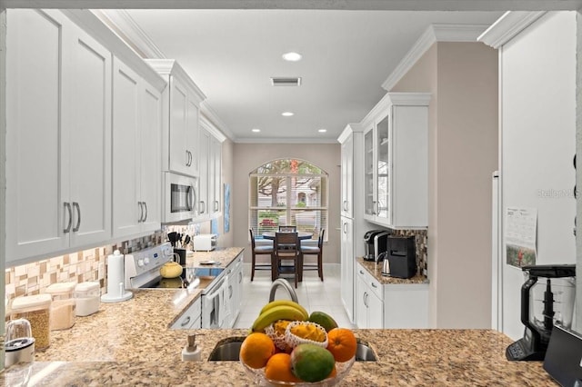 kitchen with electric stove, white cabinetry, ornamental molding, and backsplash