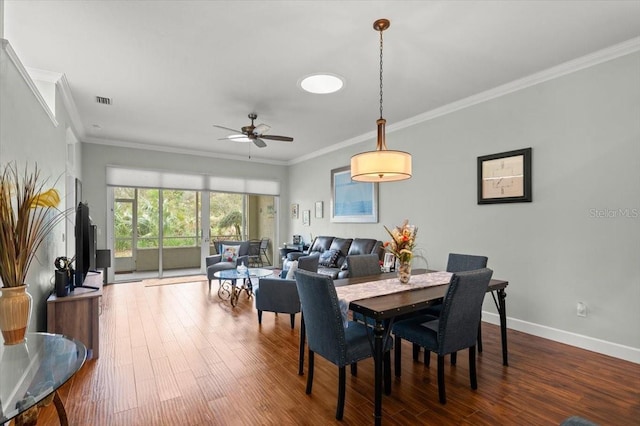 dining area with ceiling fan, ornamental molding, and wood-type flooring