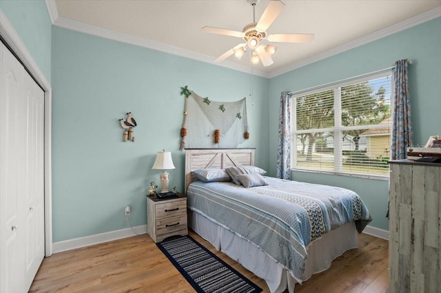 bedroom with ceiling fan, ornamental molding, a closet, and light wood-type flooring