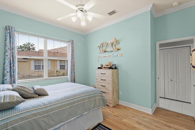 bedroom with light hardwood / wood-style flooring, ornamental molding, and ceiling fan