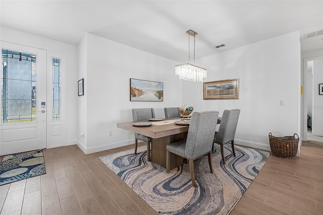 dining room with a chandelier and light hardwood / wood-style flooring