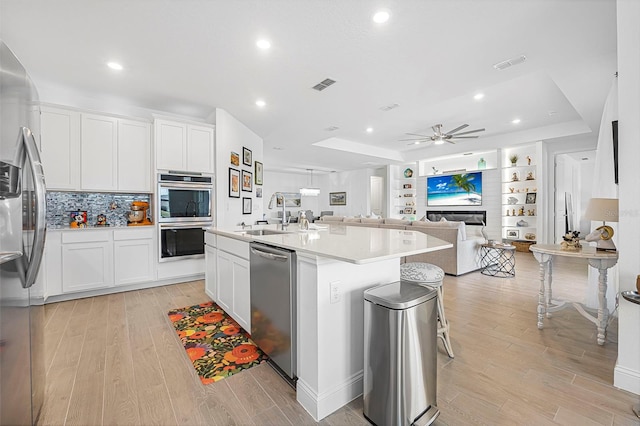 kitchen featuring white cabinetry, sink, an island with sink, and appliances with stainless steel finishes