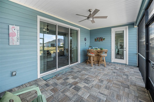 unfurnished sunroom featuring ceiling fan