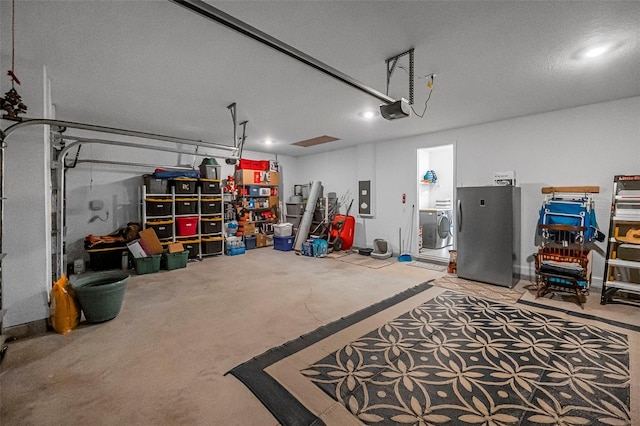 garage with a garage door opener, electric panel, and washer / clothes dryer