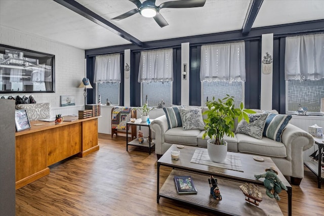 living room with beamed ceiling, ceiling fan, brick wall, and hardwood / wood-style flooring