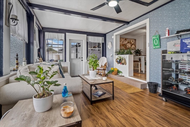 sunroom / solarium featuring beamed ceiling and ceiling fan