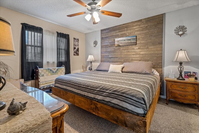 bedroom featuring ceiling fan, light colored carpet, a textured ceiling, and wood walls