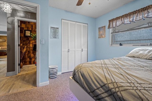 carpeted bedroom with a textured ceiling, a closet, and ceiling fan