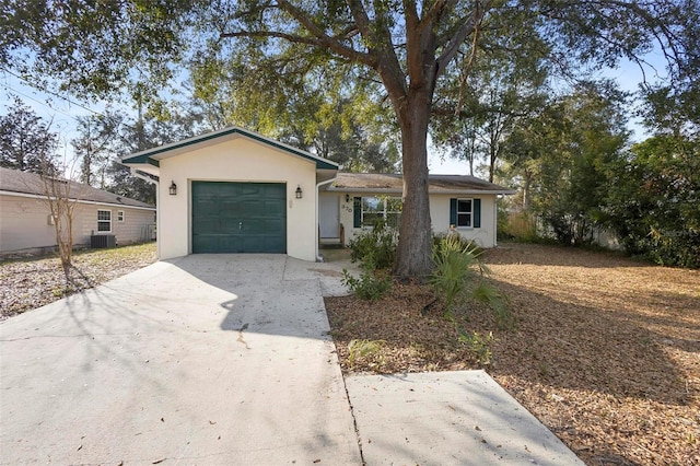 ranch-style house featuring central AC unit and a garage