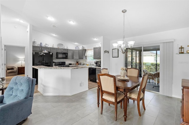 tiled dining room with vaulted ceiling and a chandelier