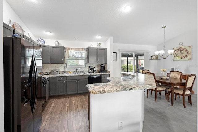 kitchen with a healthy amount of sunlight, sink, hanging light fixtures, and black appliances