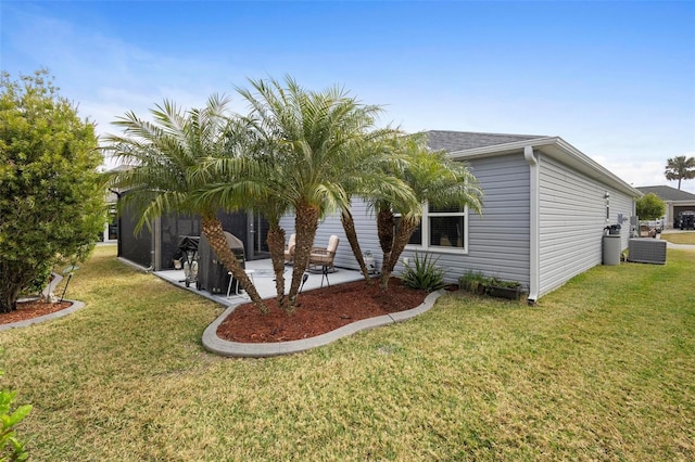 view of side of property with central AC unit, a yard, and a patio