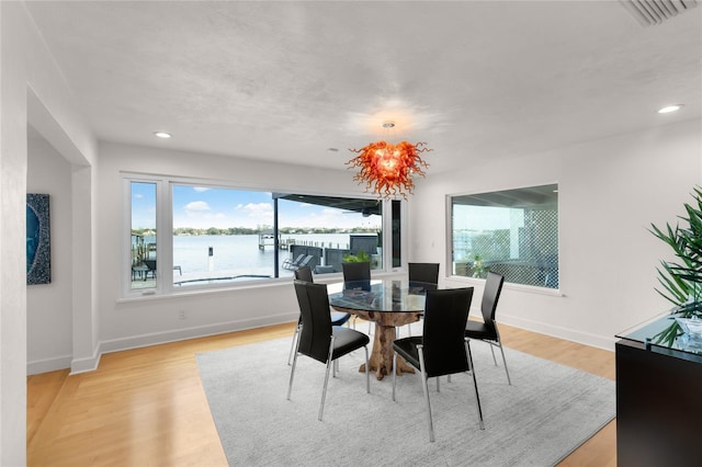 dining room with a water view and light wood-type flooring