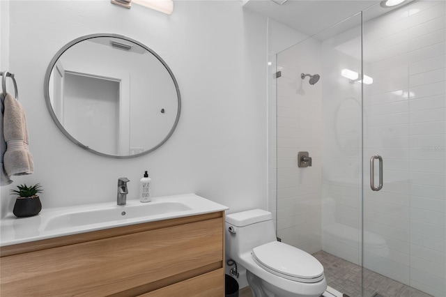 bathroom with vanity, a shower with shower door, and toilet