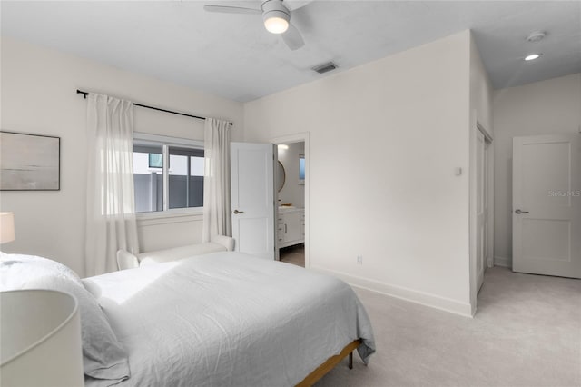 bedroom featuring connected bathroom, light carpet, and ceiling fan