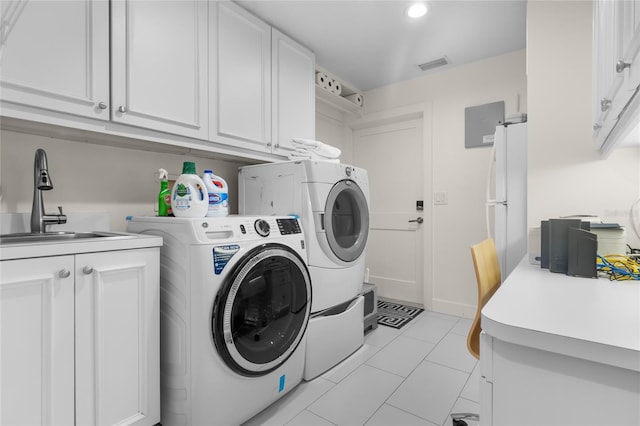 laundry area featuring light tile patterned flooring, cabinets, sink, and washer and dryer