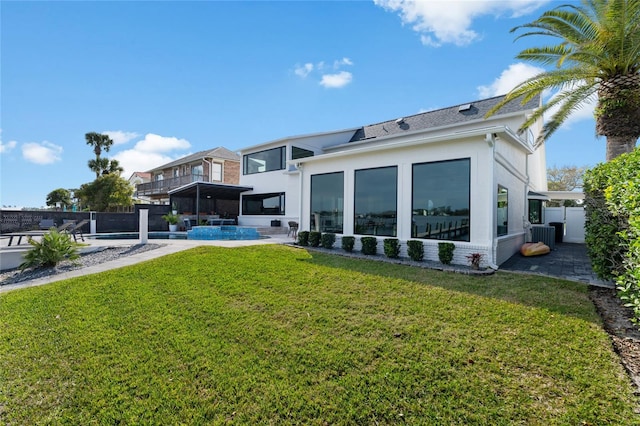 rear view of house with a fenced in pool, a lawn, a sunroom, and a patio