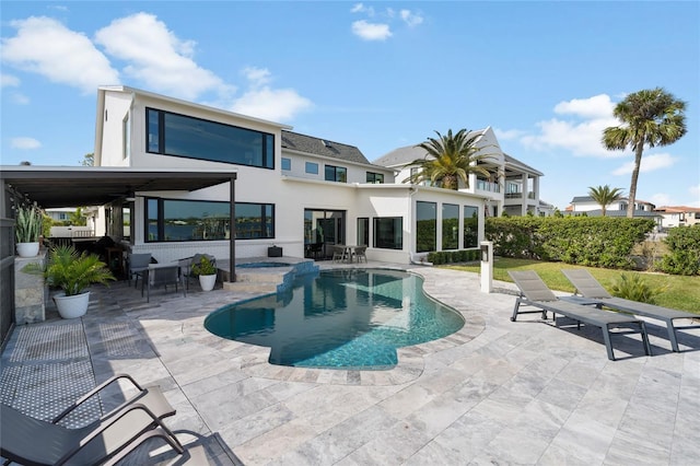 back of property with a fenced in pool and a patio