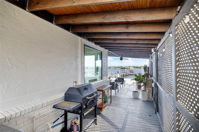 wooden deck with a water view and grilling area